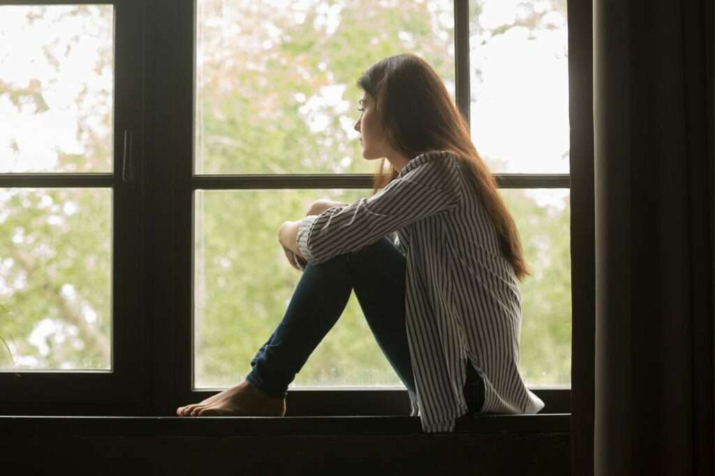 addiction - woman sitting in front of window